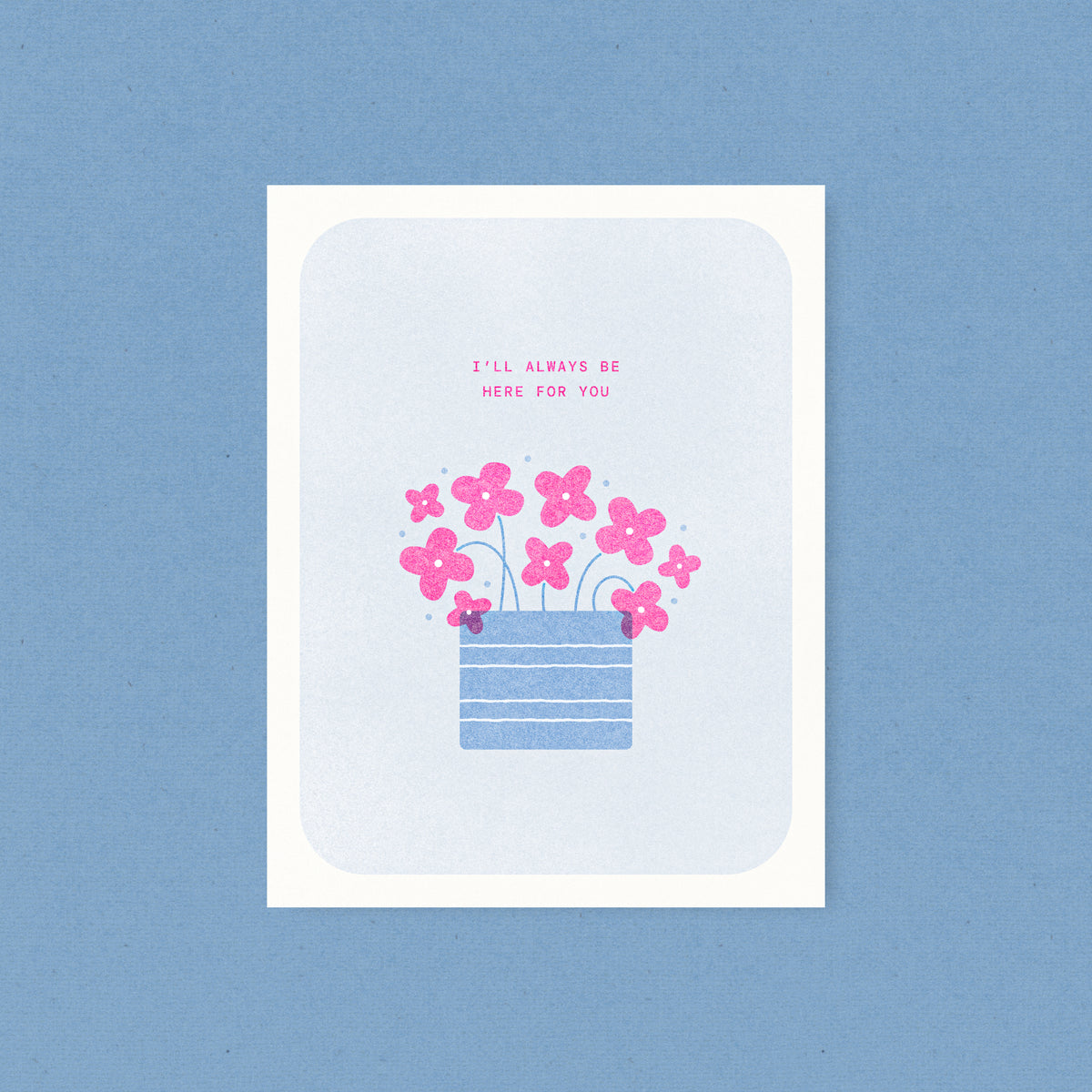 Whimsical risograph encouragement card printed with fluorescent pink and blue vegetable-based inks, featuring cute pink flowers with teal stems in a striped blue pot on a soft blue background. The words "I'll Always Be Here For You" appear above, and a kraft envelope is included. A delightful handmade card from Seattle, WA by Minna May.