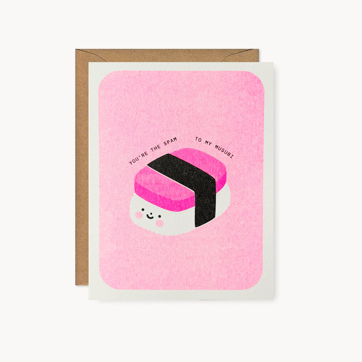 Whimsical Hawaii-inspired risograph greeting card printed with fluorescent pink vegetable-based ink, featuring a cute smiling Spam musubi with rosy cheeks and a black nori band. The words "You're the Spam to My Musubi" arch above it, and a kraft envelope is included. A delightful handmade card from Seattle, WA by Minna May Design.