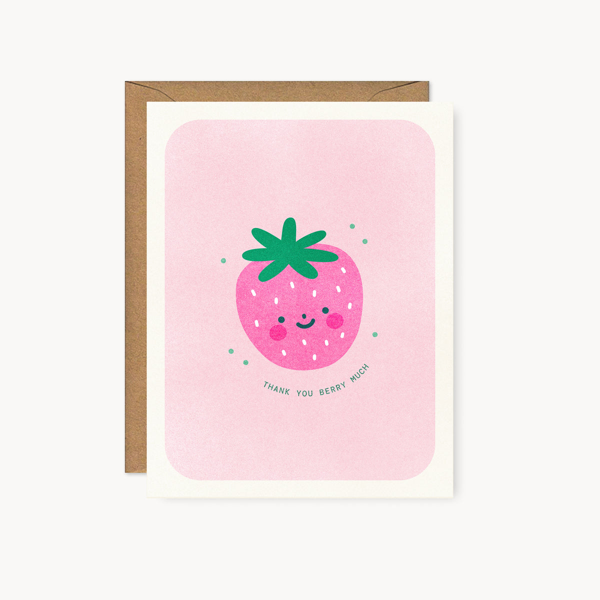 Whimsical risograph thank you card printed with fluorescent pink and green vegetable-based inks, featuring a cute smiling strawberry with bright pink cheeks and a leafy green top on a pink background. The words "Thank You Berry Much" curve beneath it, and a kraft envelope is included. A delightful handmade card from Seattle, WA by Minna May.