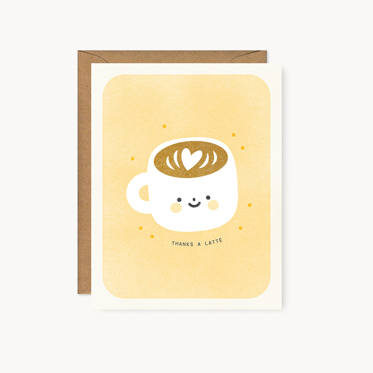 Whimsical risograph thank you card printed with yellow vegetable-based inks, featuring a cute smiling latte mug filled with coffee with a heart latte art on a yellow background. The words "Thanks a latte" curve beneath it, and a kraft envelope is included. A delightful handmade card from Seattle, WA by Minna May.